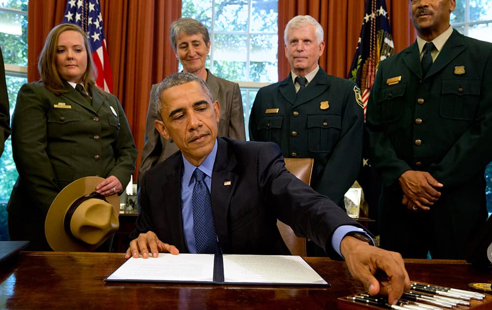 President Barack Obama, signs designations for three new national monuments; Berryessa Snow Mountain in California, Waco Mammoth in Texas, and the Basin and Range in Nevada, in the Oval Office of the White House.