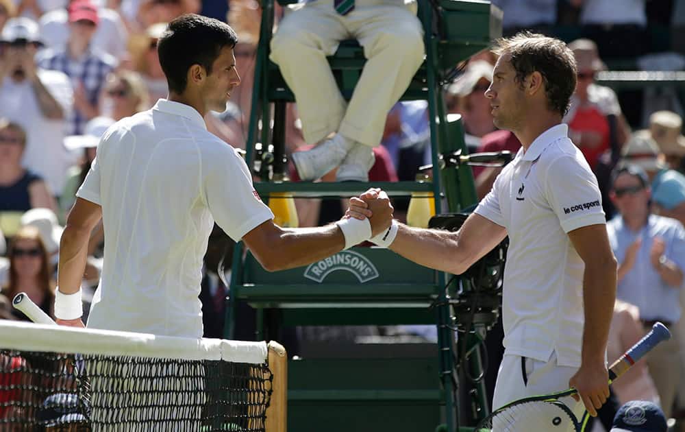 Novak Djokovic of Serbia shakes hands at the net with Richard Gasquet of France after winning their men's singles semifinal match at the All England Lawn Tennis Championships in Wimbledon.