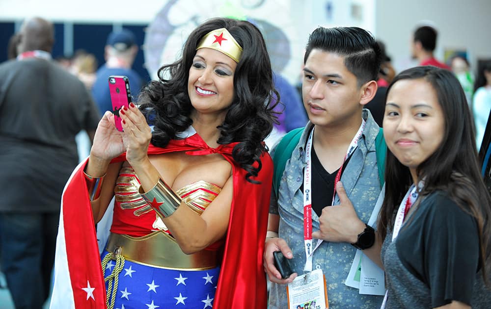 Michelle Camarillo, dressed as Wonder Woman, looks at a selfie on the second day of the 2015 Comic-Con International held at the San Diego Convention Center, in San Diego. 