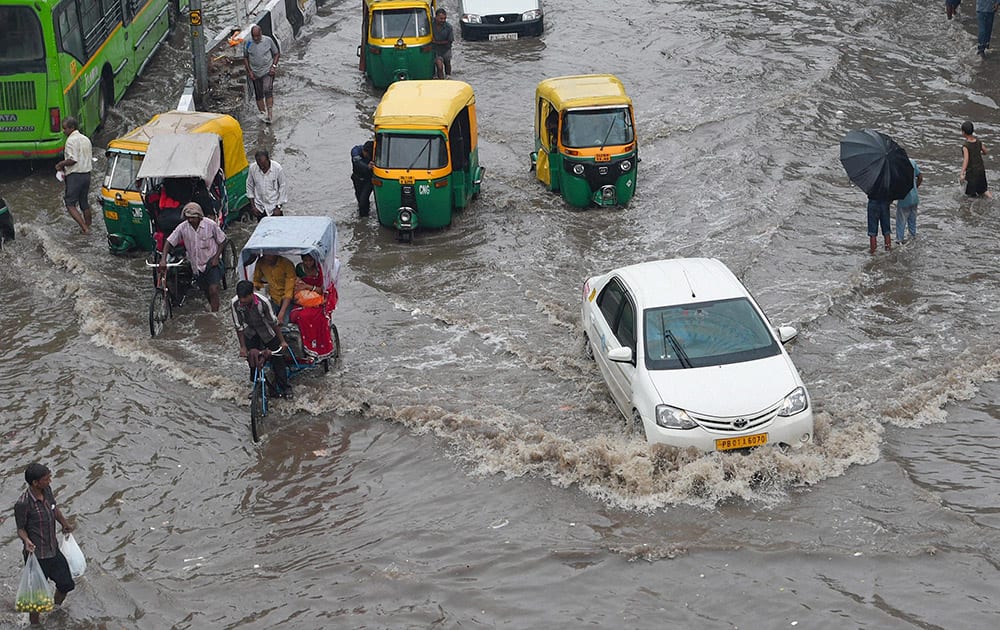 Traffic moves slowly at waterlogged roads near New Delhi Railway Station during rains.