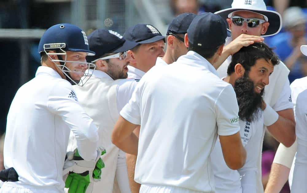 England’s Moeen Ali is congratulated after trapping Australia’s David Warner LBW for 52 runs during day four of the first Ashes Test cricket match, in Cardiff, Wales.