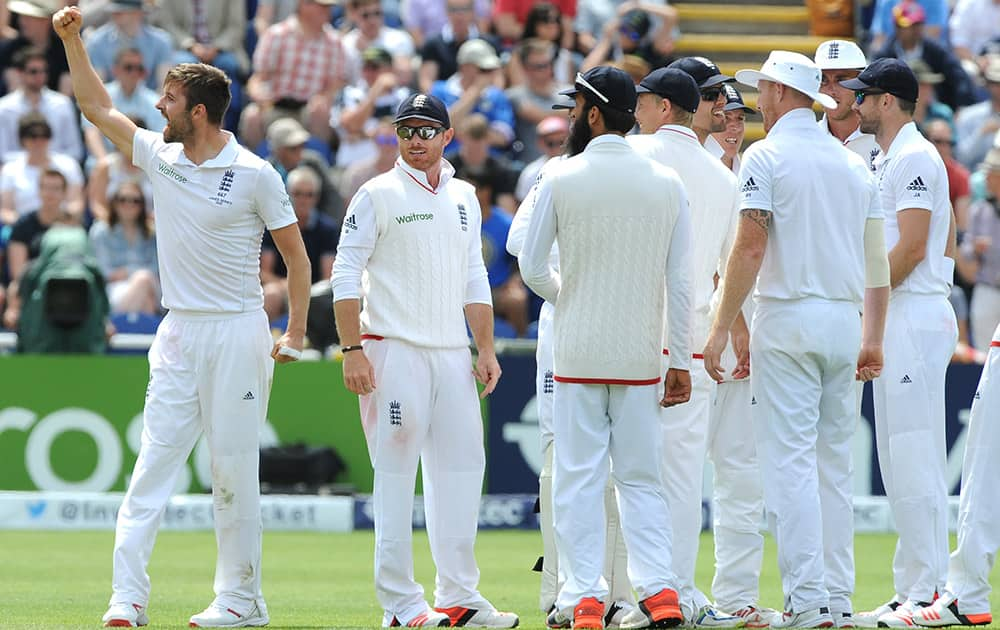 England’s Mark Wood celebrates towards fans after bowling Australia’s Adam Voges caught England’s Jos Buttler for 1 run during day four of the first Ashes Test cricket match, in Cardiff, Wales.