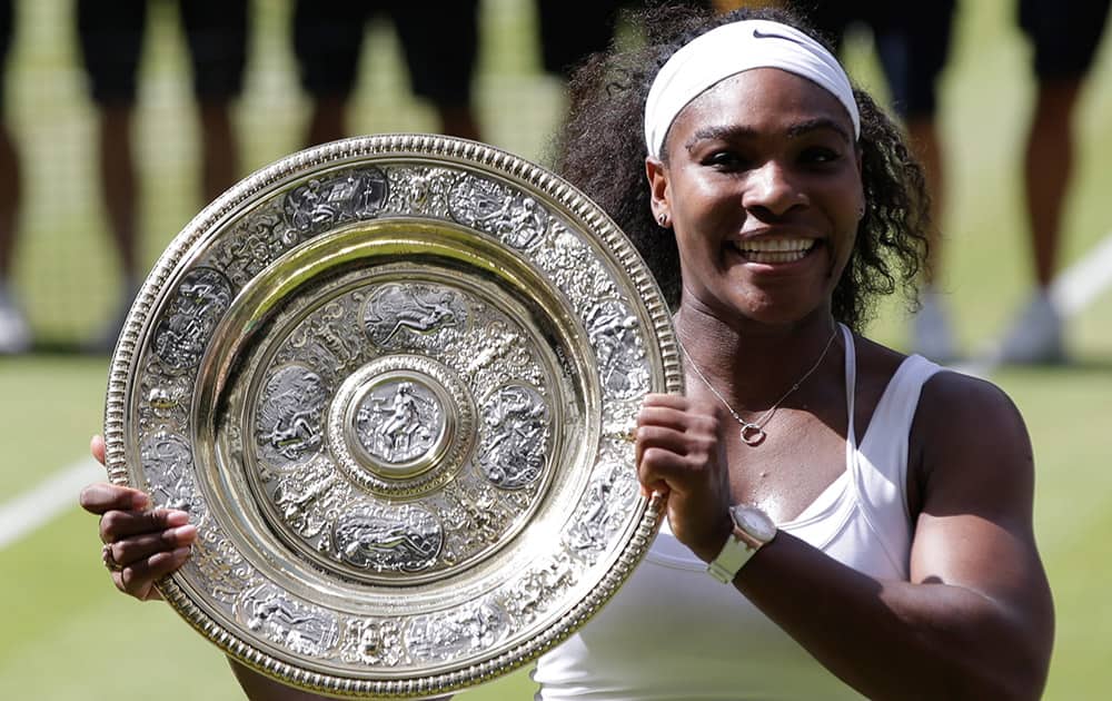 Serena Williams of the United States holds up the trophy after winning the women's singles final against Garbine Muguruza of Spain, at the All England Lawn Tennis Championships in Wimbledon, London.