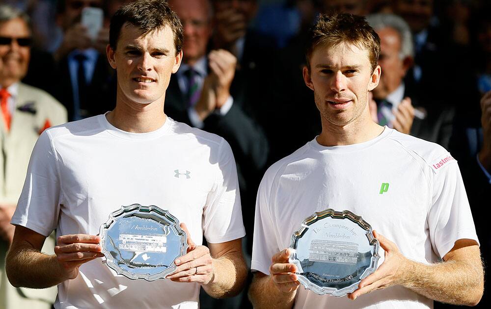 Jamie Murray of Britain, left, and John Peers of Australia hold their runners up trophies after Horia Tecau of Romania and Jean-Julien Rojer of the Netherlands win the men's doubles final at the All England Lawn Tennis Championships in Wimbledon, London.