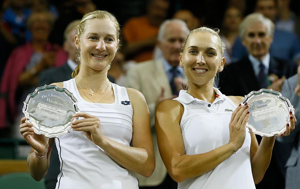 Ekaterina Makarova of Russia, left, and Elena Vesnina of Russia hold their runner up trophies after Martina Hingis of Switzerland and Sania Mirza of India win the women's doubles final against at the All England Lawn Tennis Championships in Wimbledon, London.