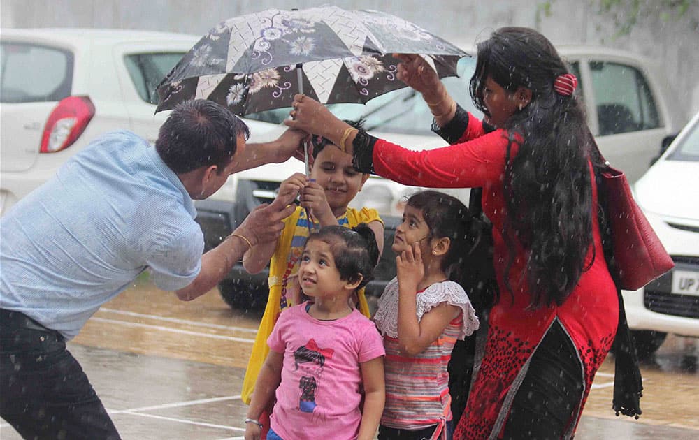 Students walk back home after attending school during rains in Allahabad.