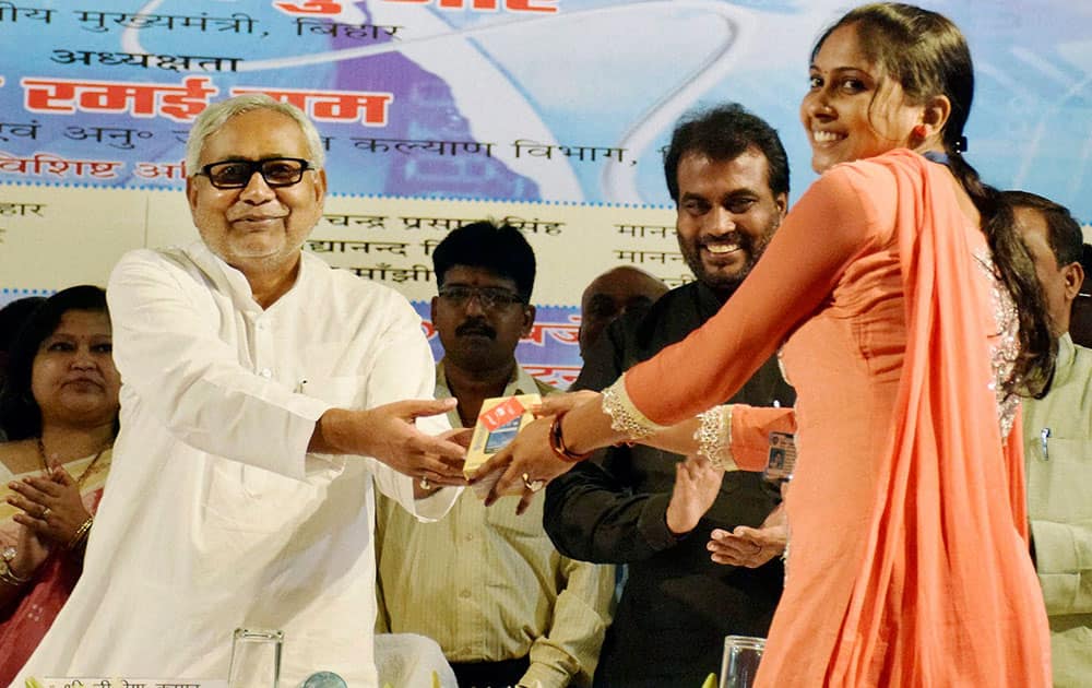 Bihar Chief Minister Nitish Kumar distributes mobile phones to Vikas Mitra members during an orientation program of Vikas Mitra in Patna.