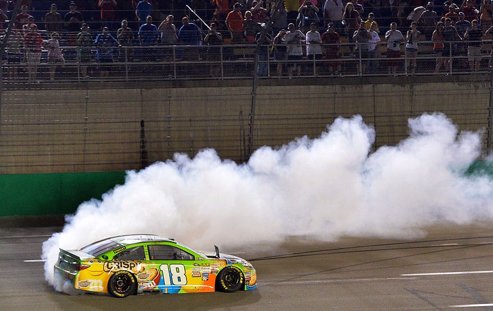 Kyle Busch does a burnout after his victory in the NASCAR Sprint Cup series auto race at Kentucky Speedway in Sparta, Ky.