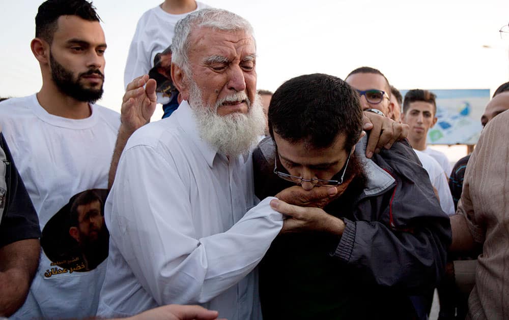 Palestinian Khader Adnan kisses his fathers hand after his release from an Israeli prison in the West Bank village of Arrabeh near Jenin. Israel has released a Palestinian prisoner who recently ended a 55-day hunger strike. Looking thin and pale, Adnan was transferred in an Israeli ambulance Sunday and handed to the Palestinian medical service. 