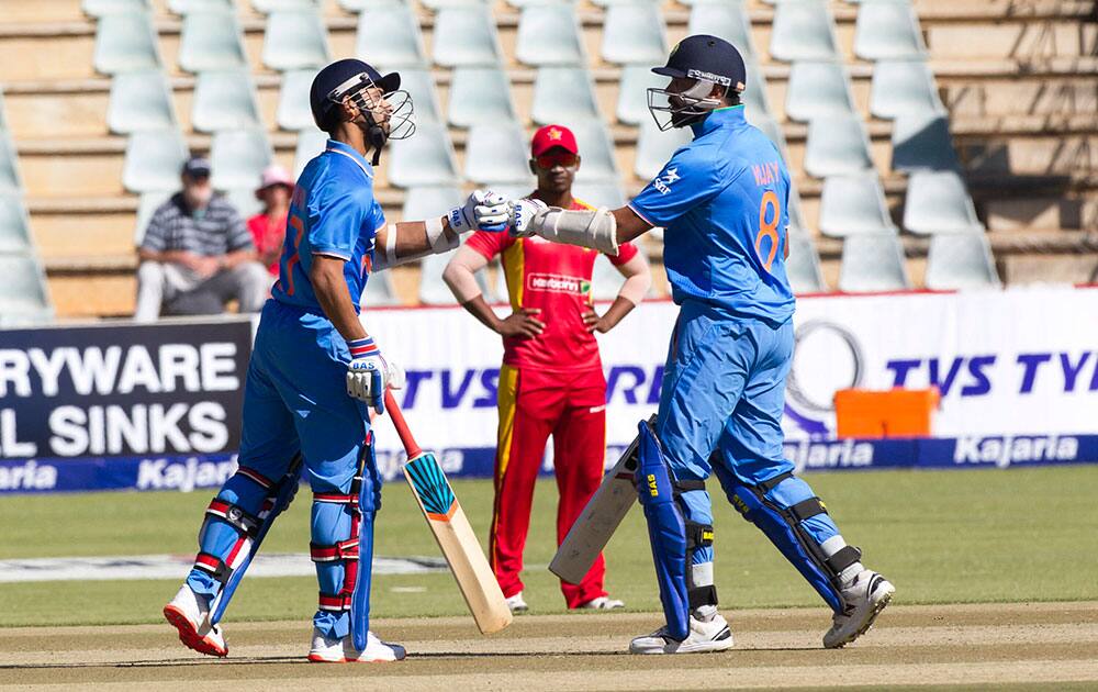 Indian batsman Ajinkya Rahane,left, and Murali Vijay touch gloves in the second one-day international cricket match against Zimbabwe in Harare, Zimbabwe.