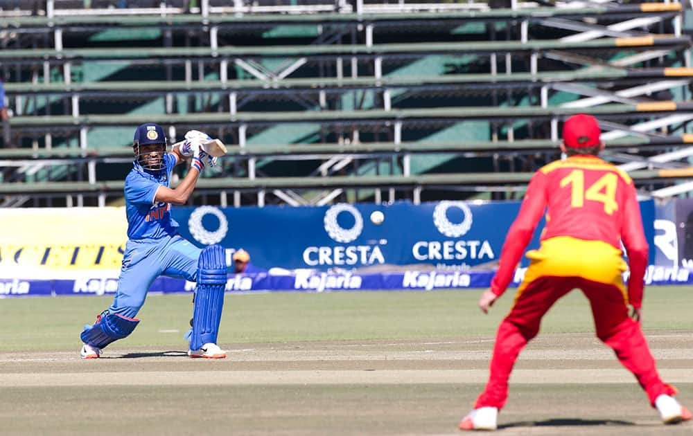 Indian batsman Ajinkya Rahane, left, plays a shot to Zimbabwean fielder Sean Williams on the second day of the One Day International cricket match against Zimbabwe in Harare, Zimbabwe.