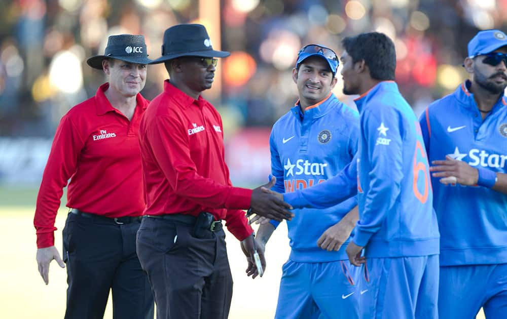 Indian cricket players shake hands with the umpires after the match on the second day of the One Day International cricket match against Zimbabwe in Harare, Zimbabwe.