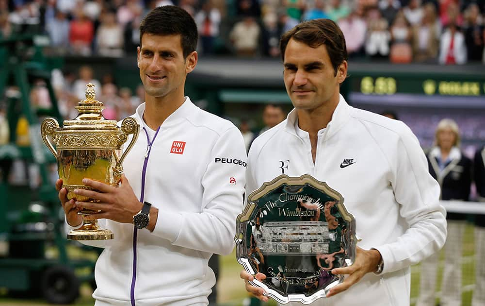 Novak Djokovic of Serbia, left, holds the trophy after winning the men's singles final against Roger Federer of Switzerland at the All England Lawn Tennis Championships in Wimbledon, London.