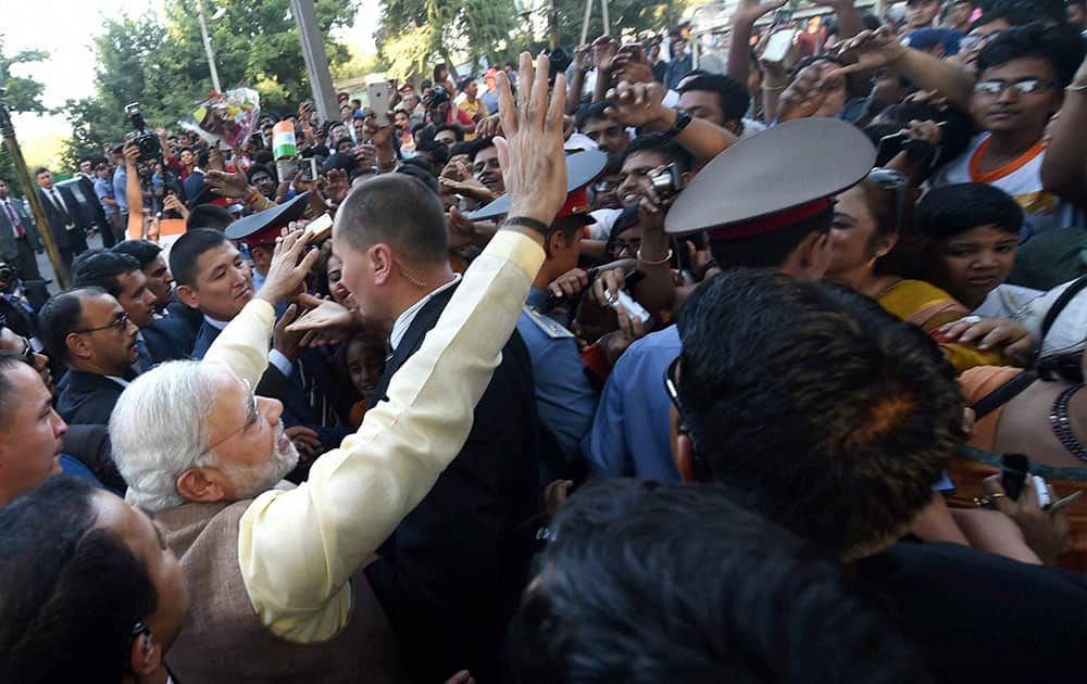 Prime Minister Narendra Modi waves to people after unveiling the Mahatam Gandhi statute in Bhishkek.