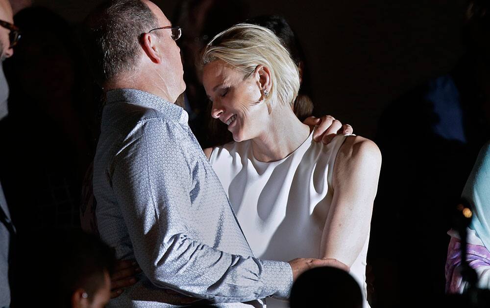 Prince Albert of Monaco and his wife Princess Charlene react before the show of British singer Robbie Williams, in Monaco. 