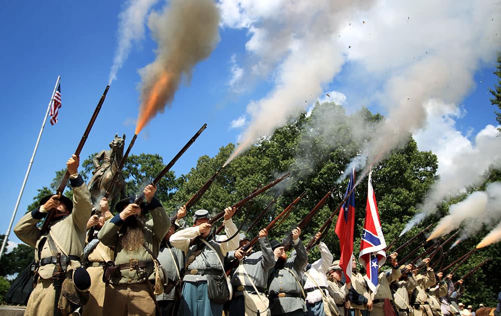 Historical re-enactors fire a musket salute in front of the statue and tomb of Nathan Bedford Forrest, rebel general, slave trader and early Ku Klux Klan member, during a celebration of Forrest's 194th birthday at Health Sciences Park in Memphis, Tenn. 