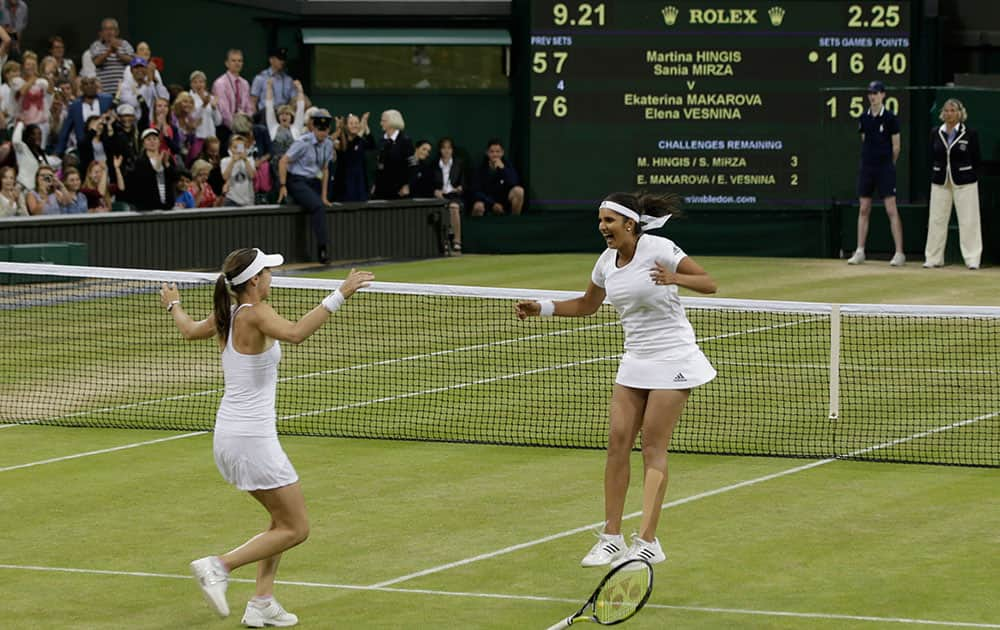 Martina Hingis of Switzerland, left, and Sania Mirza of India celebrate winning the women's doubles final against Ekaterina Makarova of Russia and Elena Vesnina of Russia at the All England Lawn Tennis Championships in Wimbledon, London.