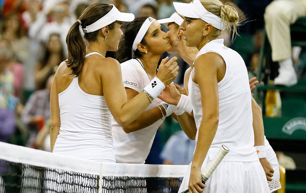 Martina Hingis of Switzerland, left, and Sania Mirza of India celebrate winning the women's doubles final against Ekaterina Makarova of Russia and Elena Vesnina of Russia at the All England Lawn Tennis Championships in Wimbledon, London.