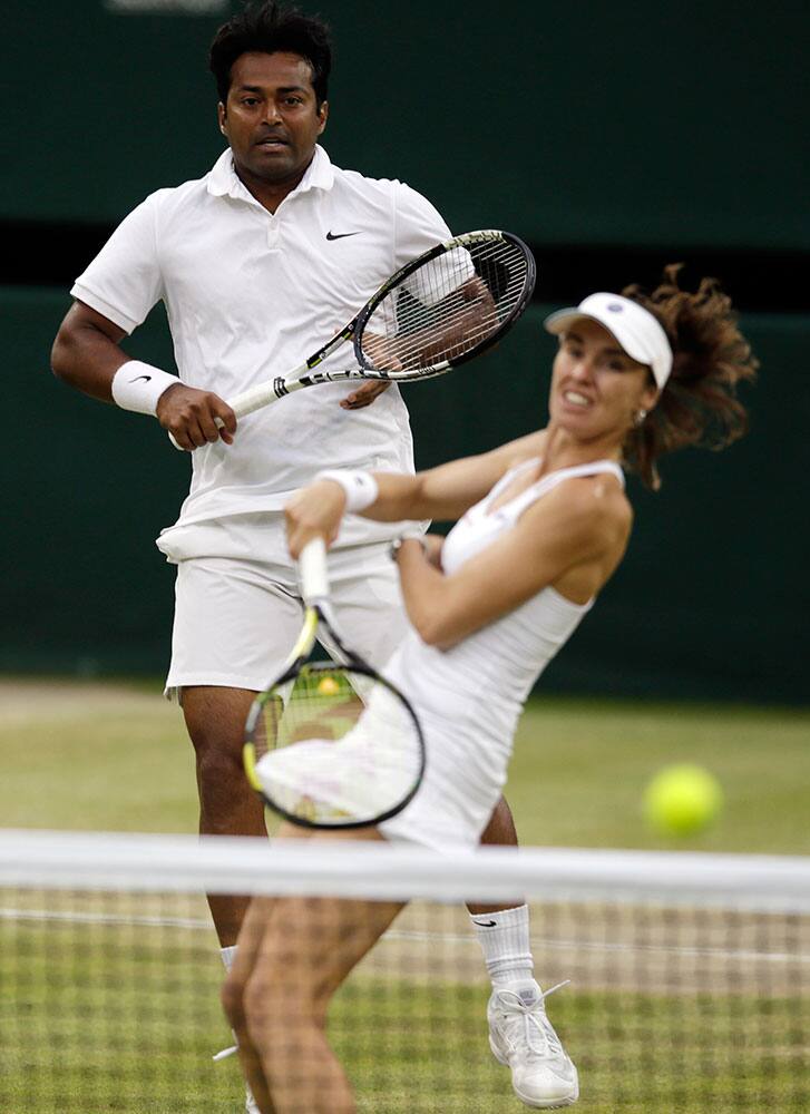 Leander Paes of India, left, and Martina Hingis of Switzerland return a ball to Alexander Peya of Austria and Timea Babos of Hungary in the mixed doubles final at the All England Lawn Tennis Championships in Wimbledon, London.