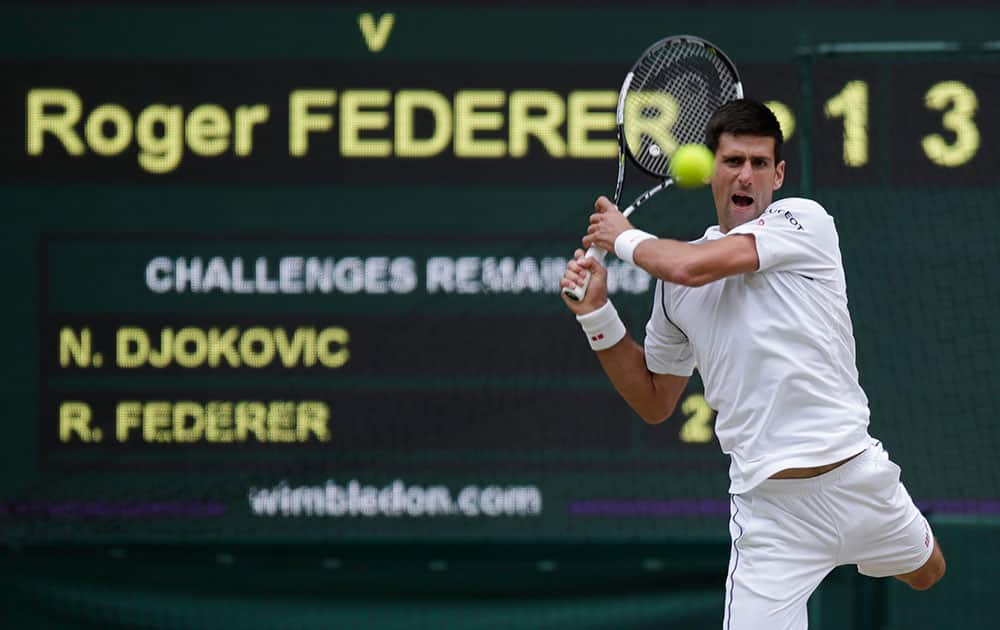 Novak Djokovic of Serbia plays a return to Roger Federer of Switzerland during the men's singles final at the All England Lawn Tennis Championships in Wimbledon, London.