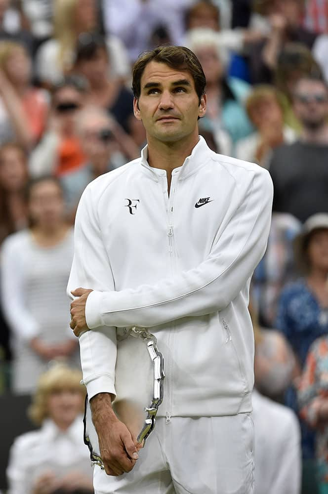 Roger Federer of Switzerland holds the runner up trophy up after being defeated by Novak Djokovic of Serbia in the men's singles final at the All England Lawn Tennis Championships in Wimbledon, London.