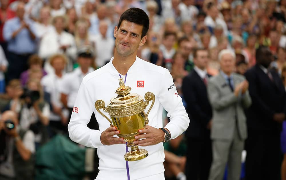 Novak Djokovic of Serbia holds the trophy after winning the men's singles final against Roger Federer of Switzerland at the All England Lawn Tennis Championships in Wimbledon, London.