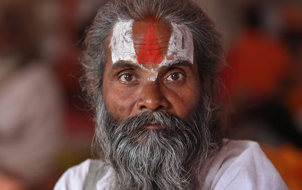 A stranded Hindu pilgrim looks at camera as he waits for the resumption of the Amarnath Pilgrimage at a Hindu temple in Jammu.