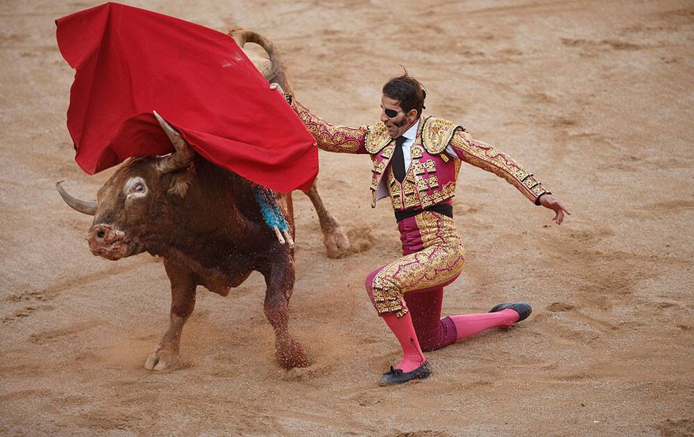 Spanish bullfighter Juan Jose Padilla performs with a Garcigrande ranch fighting bull during a bullfight of the San Fermin festival in Pamplona, Spain.