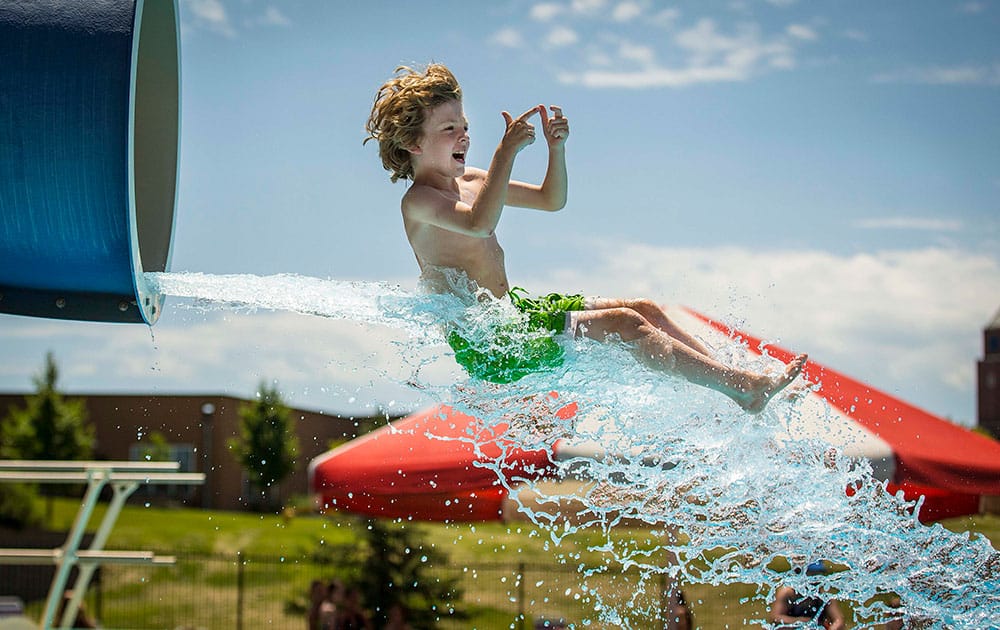 Bodie Emanoil, 10, exits the water slide at Clive Aquatic Center as temperatures rise in Clive, Iowa. 