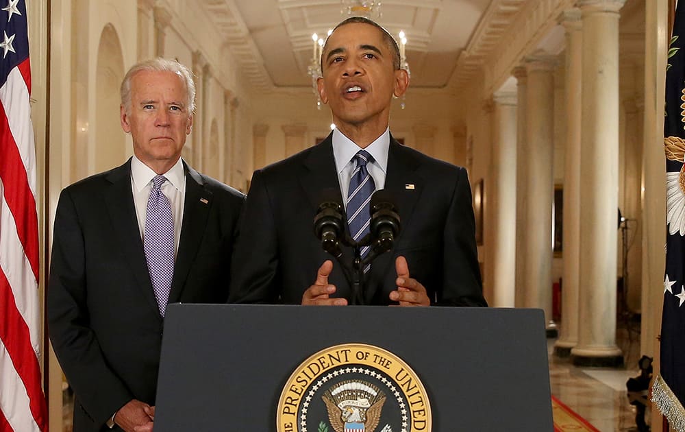 President Barack Obama, standing with Vice President Joe Biden, delivers remarks in the East Room of the White House in Washington.