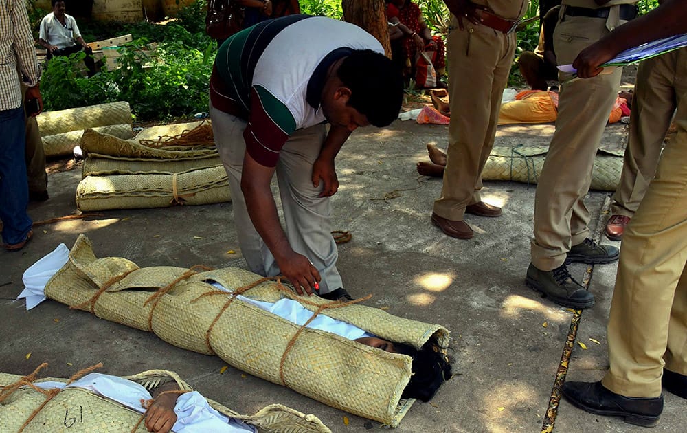 Policemen stand near dead bodies of victims of a stampede during a Hindu religious bathing festival on the bank of the Godavari River in Rajahmundry, Andhra Pradesh.