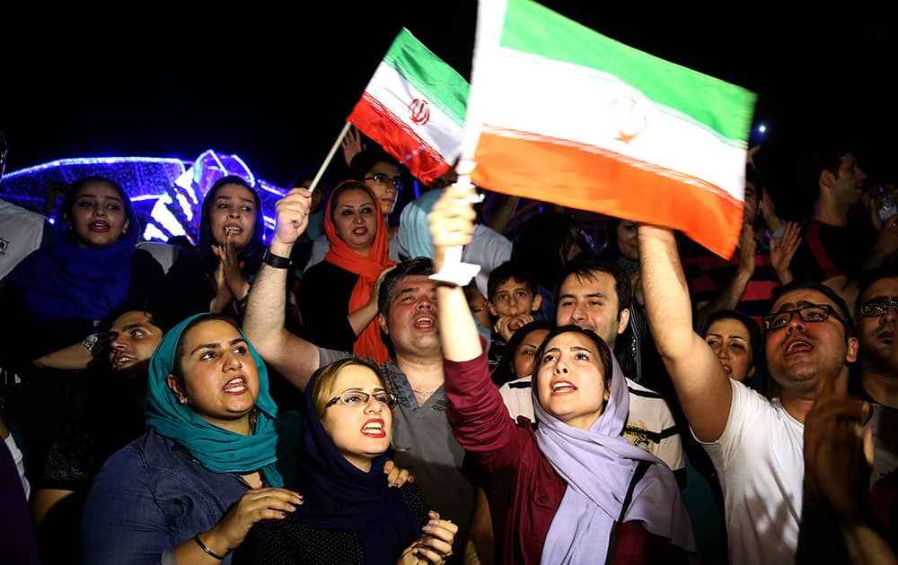 Jubilant Iranians sing and wave Iran flags during street celebrations following a landmark nuclear deal, in Tehran, Iran.