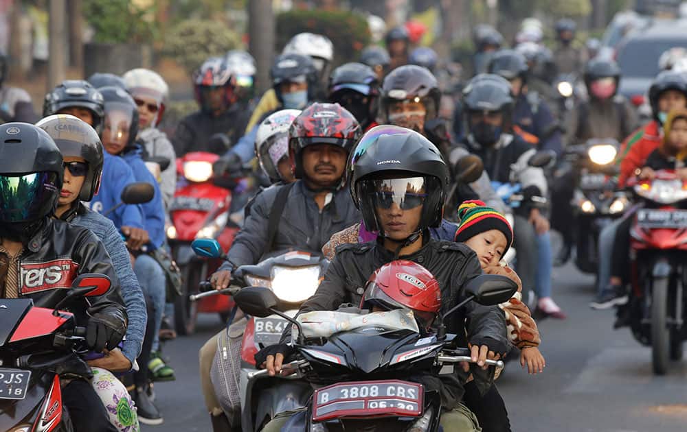 People ride motorcycles for going home at Bekasi, outskirt of Jakarta, Indonesia. The mass exodus out of the capital and other major cities in the world's most populous Muslim country is underway as millions are heading to their hometowns to celebrate Eid al-Fitr this week which will mark the end of the holy fasting month of Ramadan.
