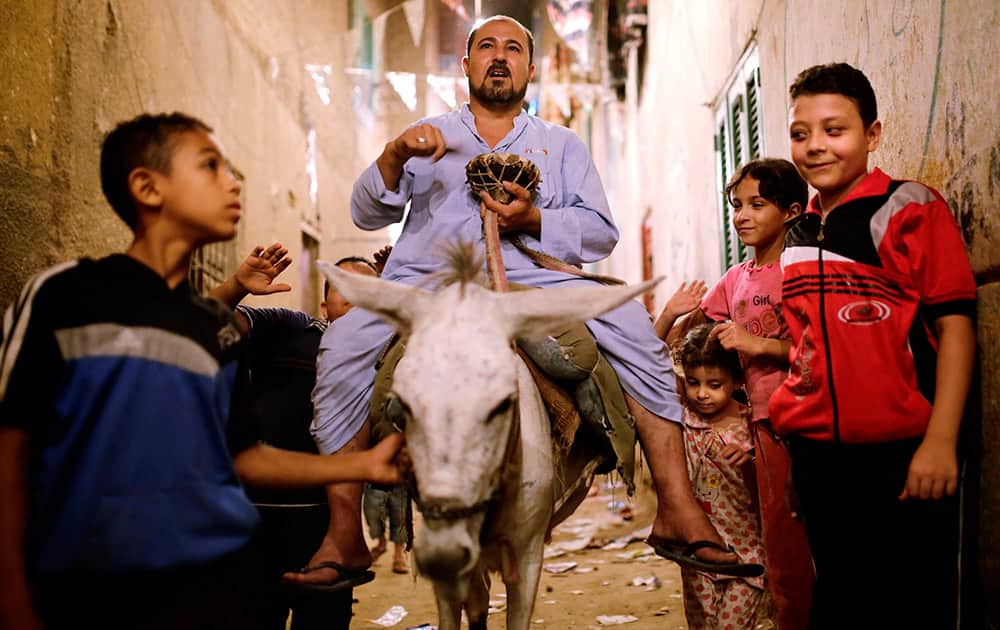 Children gather around Essam Sayed, a 45-year-old 