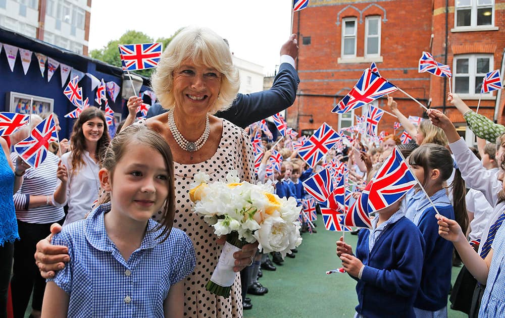 Well wishers wave Union Flags as the Duchess of Cornwall visits St. Peter's Eaton Square Church of England Primary School in London.