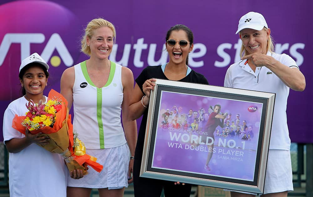 Former tennis champion Martina Navratilova, presents a token to Sania Mirza, as they pose for photographs with an Indian student and Women's Tennis Association (WTA) Asia-Pacific Vice President Melissa Pine, during the WTA Future Stars special tennis clinic at the Sania Mirza Tennis Academy in Hyderabad.