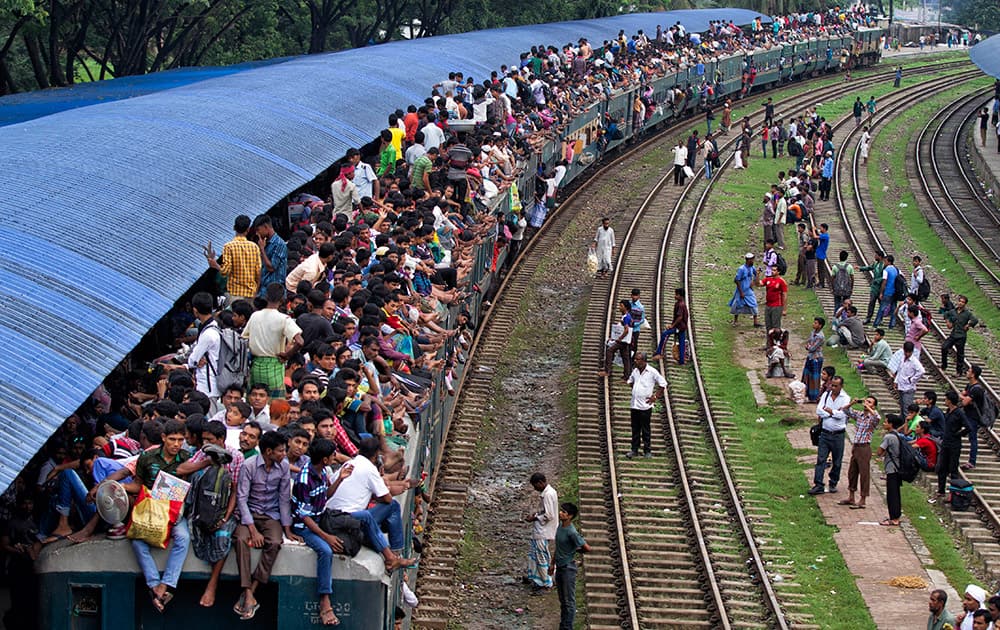 Bangladeshi passengers sit on the roof of a train, as they head to their homes to celebrate Eid al-Fitr in Dhaka, Bangladesh.