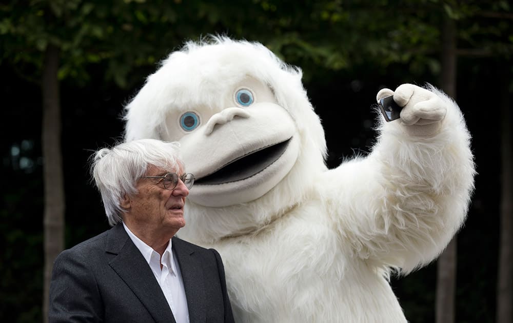 Formula One boss Bernie Ecclestone has a selfie taken with a person dressed in a Yeti costume during a photocall to promote the Mongol Rally outside the headquarters of Formula One Group in London.