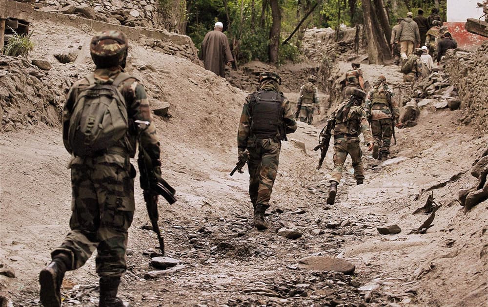 Army soldiers walking towards Gagangir village for rescue operations, after series of deadly cloudbursts damaged and washed away houses, shops and vehicles.