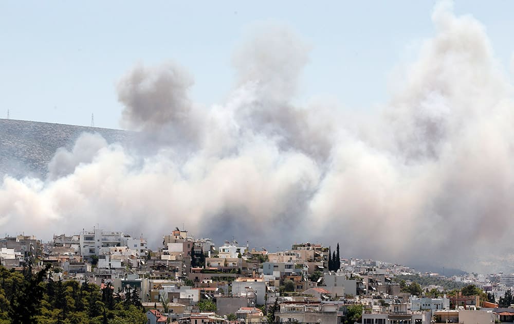 Smoke from a fire travels over the eastern suburbs of Athens. Another fire in Peloponnese, in southern Greece, is burning out of control. 