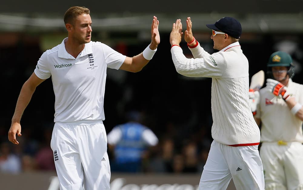 England's Stuart Broad and Joe Root celebrate taking the wicket of Australia's Chris Rogers on the second day of the second Ashes Test match between England and Australia, at Lord's cricket ground in London.