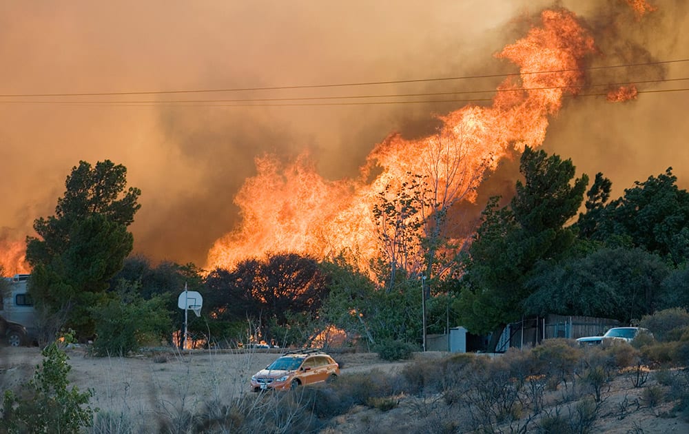 Flames rise from a fire over a cluster of homes in Oak Hills, Calif.