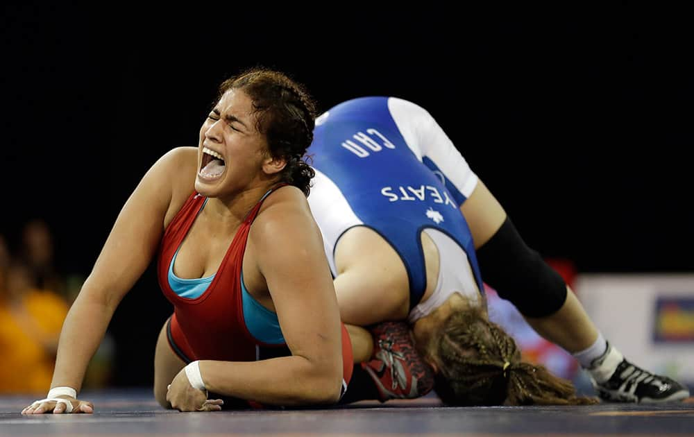 Venezuela's Maria Acosta yells as her legs twist with Canada's Dori Yeats, right, during their women's freestyle 69 kg final in wrestling competition in the Pan Am Games in Mississauga, Ontario. Yeats won the gold medal in the match. 