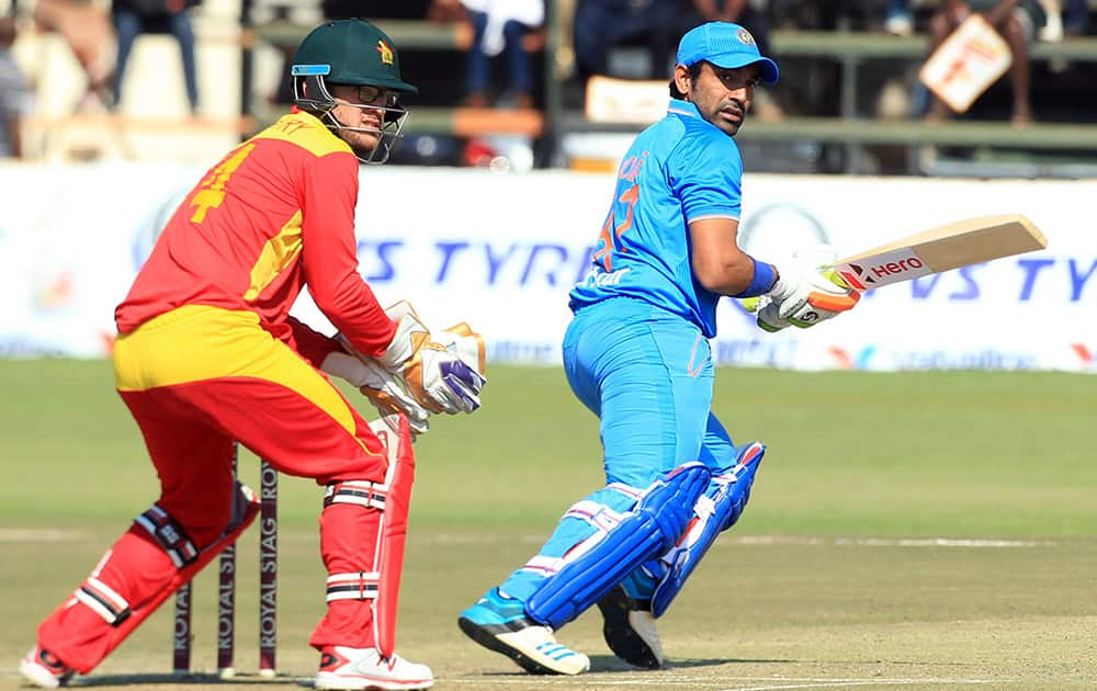 Robin Uthappa, right, plays a shot as Zimbabwean wicketkeeper Charles Coventry looks on during the Twenty20 cricket match in Harare, Zimbabwe.