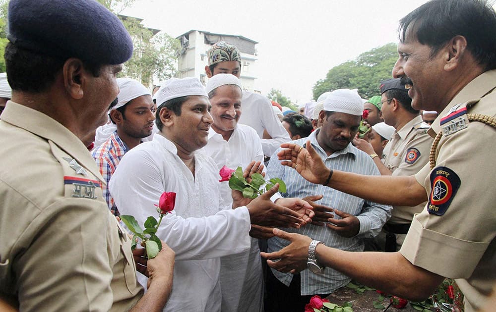 Police personnel offer roses to Muslims on the occasion of Eid-ul-Fitr festival in Thane, Mumbai.