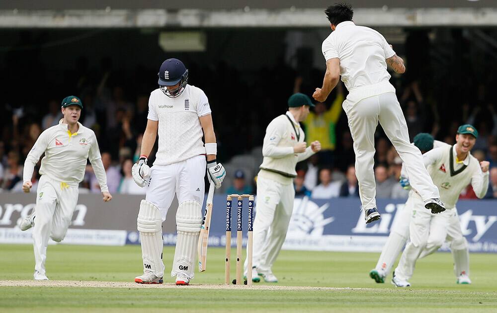 England's Joe Root looks down as Australia's Mitchell Johnson jumps to celebrate taking his wicket on the second day of the second Ashes Test match between England and Australia, at Lord's cricket ground in London.