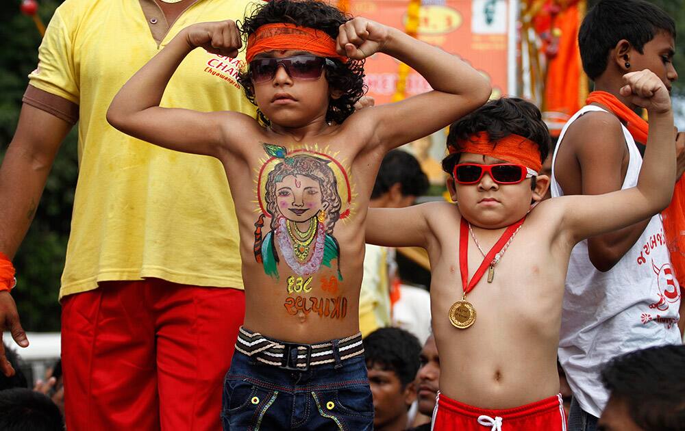 Boys display their muscles during the annual Rath Yatra in Ahmadabad.