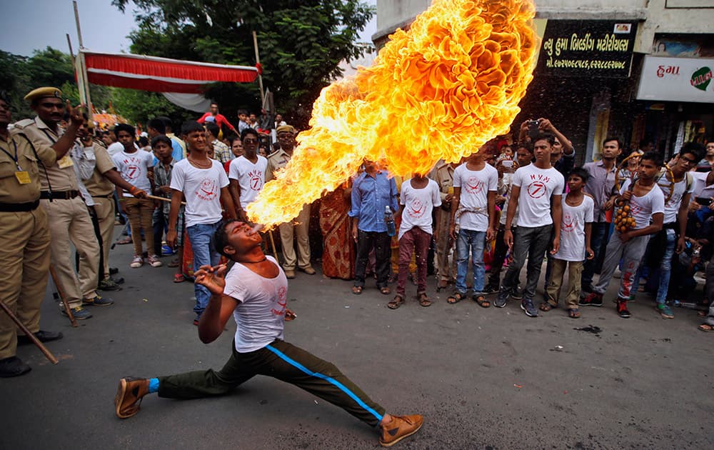 A man performs fire stunt during the annual Rath Yatra or Chariot procession of Lord Jagannath in Ahmadabad.