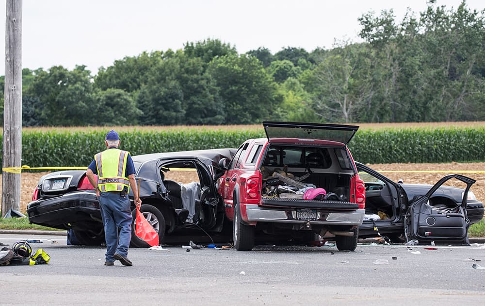 Authorities investigate the scene after a fatal crash between a limousine and sports utility vehicle in Cutchogue, N.Y. Multiple visitors to New York wine country were killed Saturday and others were seriously injured in the crash on the eastern end of Long Island, law enforcement officials said.