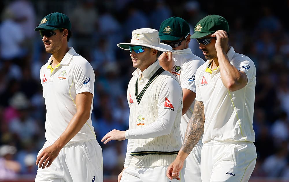 Australia's captain Michael Clarke leaves the pitch with his players after bowling out England for 312 on the third day of the second Ashes Test match between England and Australia, at Lord's cricket ground in London.